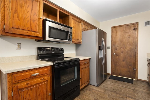 kitchen with stainless steel appliances and dark hardwood / wood-style flooring