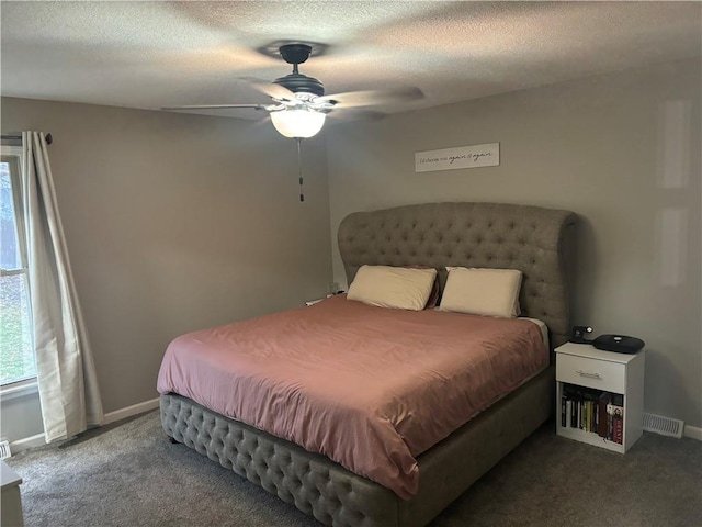 carpeted bedroom featuring ceiling fan and a textured ceiling