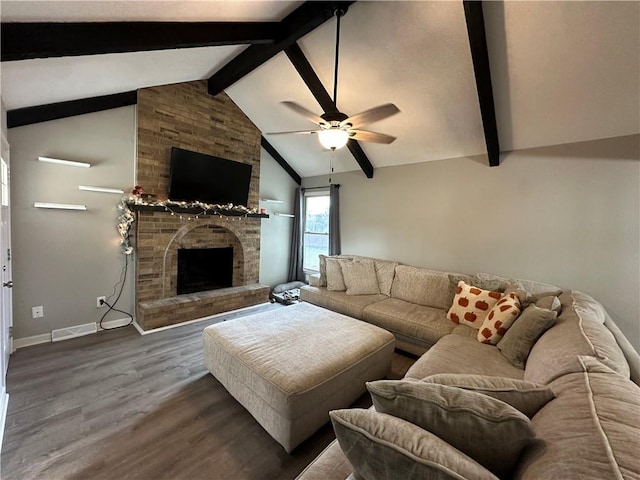 living room featuring hardwood / wood-style flooring, ceiling fan, a fireplace, and vaulted ceiling with beams