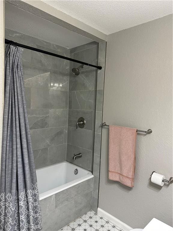 bathroom featuring shower / bath combination with curtain and a textured ceiling