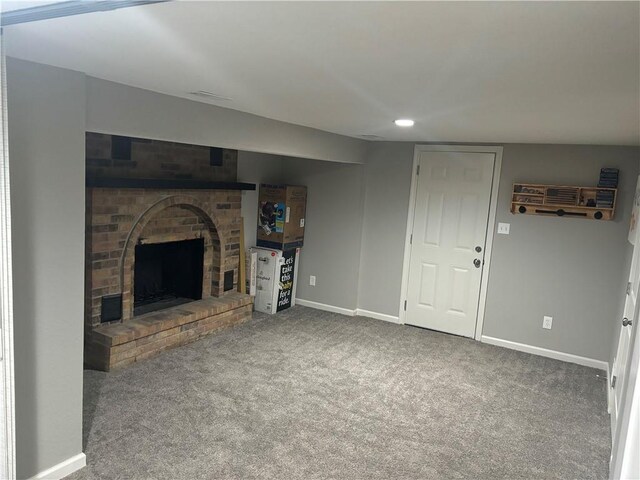 unfurnished living room with a brick fireplace and carpet floors