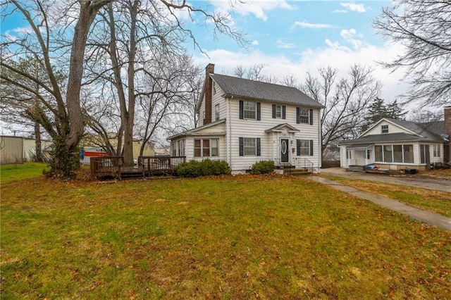 colonial inspired home featuring a wooden deck and a front yard