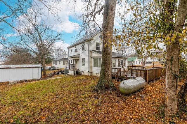 back of house featuring a lawn and a storage unit