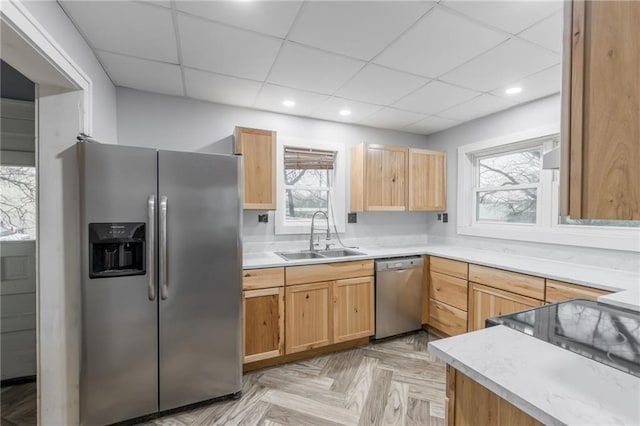 kitchen featuring a drop ceiling, sink, stainless steel appliances, and light parquet flooring