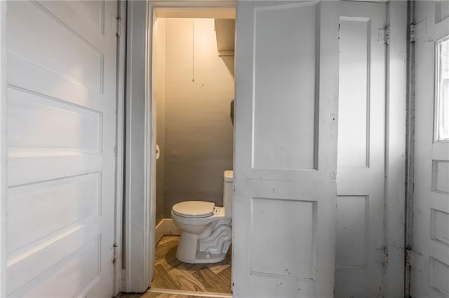 bathroom with toilet and parquet flooring