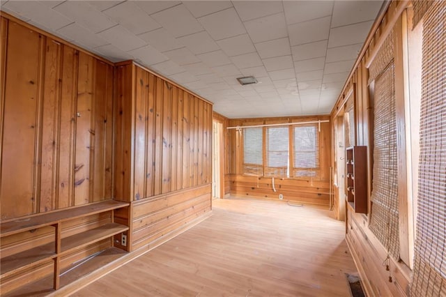 mudroom with light wood-type flooring and wood walls