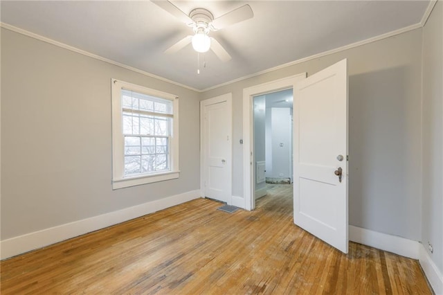 unfurnished room featuring ceiling fan, light hardwood / wood-style floors, and ornamental molding