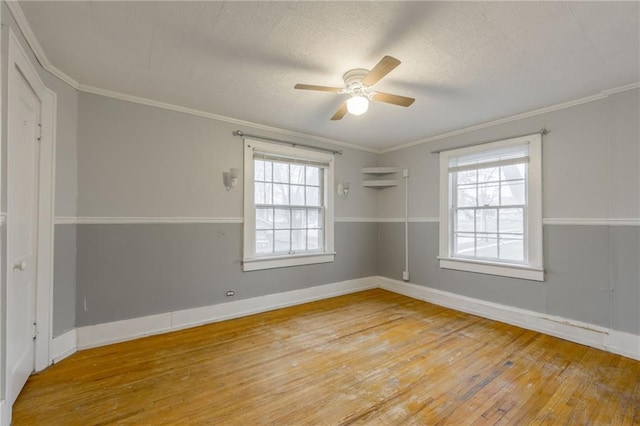 unfurnished room with hardwood / wood-style floors, plenty of natural light, ceiling fan, and ornamental molding