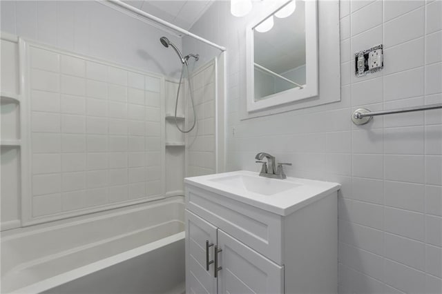 bathroom featuring shower / bathing tub combination, vanity, and tile walls