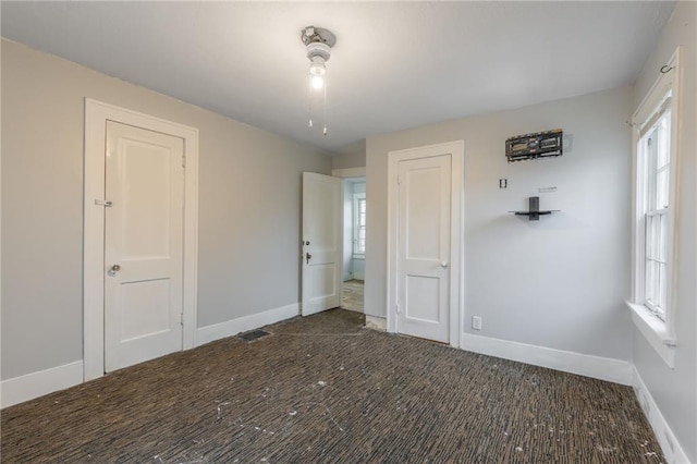 unfurnished bedroom featuring multiple windows