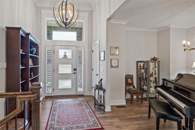 entrance foyer with crown molding, wood-type flooring, a chandelier, and a wealth of natural light