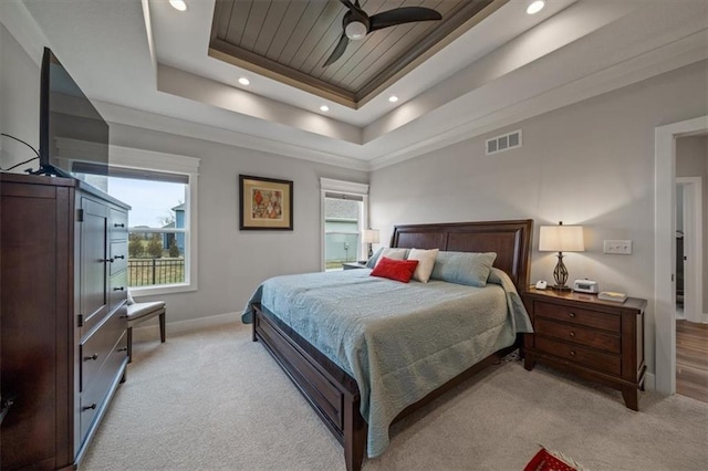 carpeted bedroom with a raised ceiling