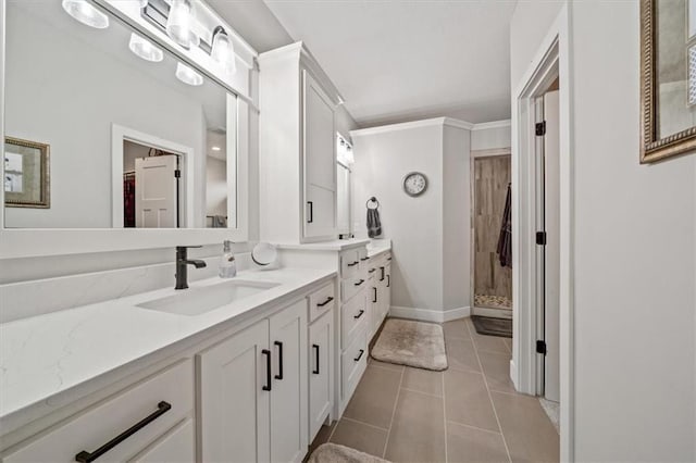 bathroom with tile patterned flooring, vanity, ornamental molding, and walk in shower