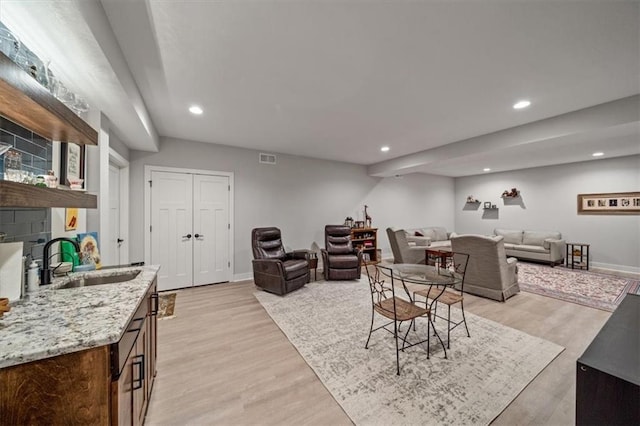 living room with sink and light hardwood / wood-style flooring