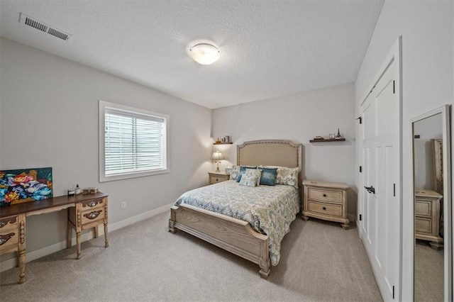 bedroom with light carpet, a closet, and a textured ceiling