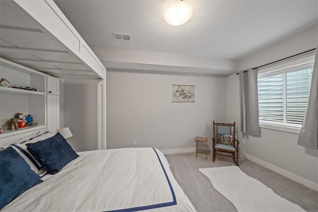 bedroom with light colored carpet and a textured ceiling