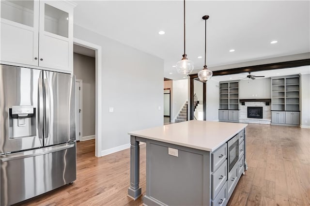 kitchen with appliances with stainless steel finishes, white cabinetry, hanging light fixtures, gray cabinetry, and a kitchen island