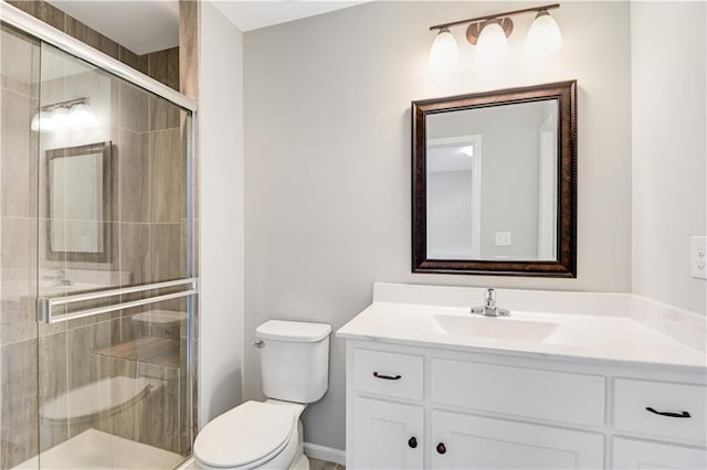 bathroom with a shower with door, vanity, and toilet