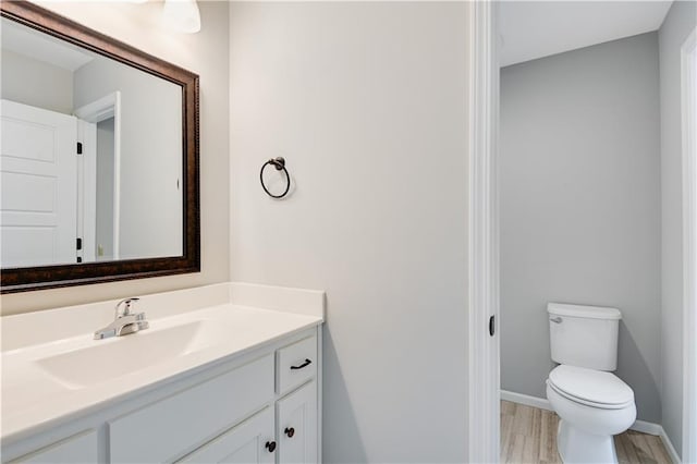 bathroom featuring vanity, wood-type flooring, and toilet