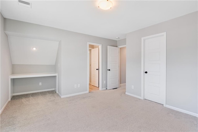 unfurnished bedroom featuring light carpet and a closet