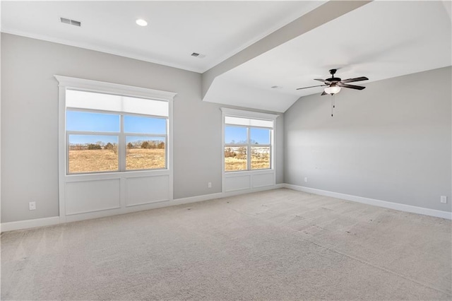 empty room featuring vaulted ceiling, light carpet, and ceiling fan