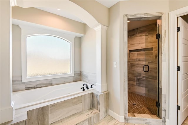 bathroom with decorative columns and independent shower and bath