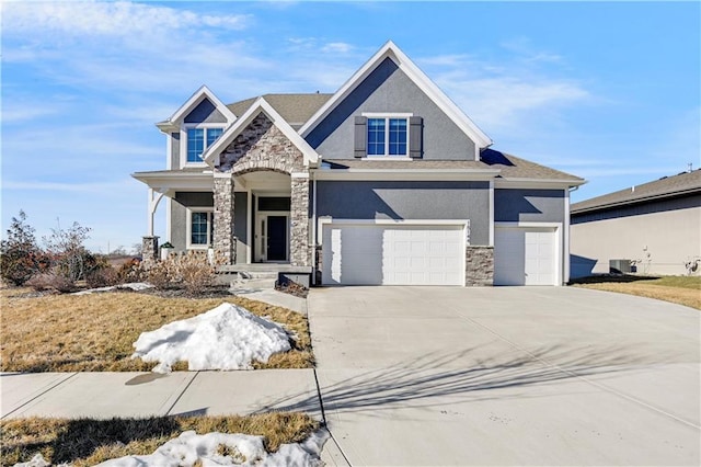 craftsman-style house featuring a garage, stone siding, concrete driveway, and stucco siding