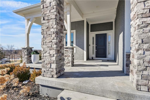 entrance to property featuring stone siding and stucco siding