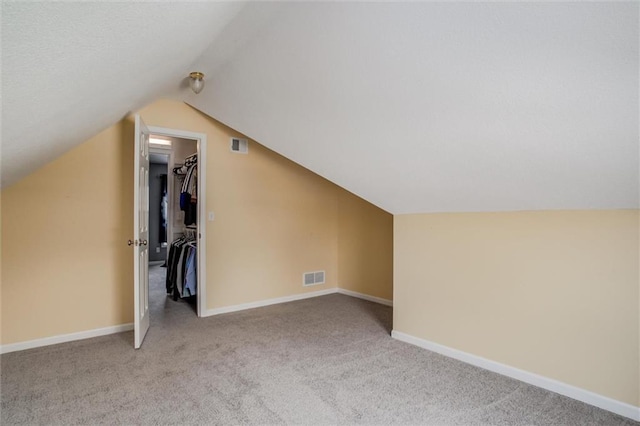 additional living space with vaulted ceiling and light colored carpet