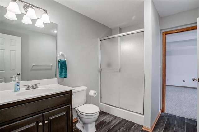 bathroom featuring vanity, toilet, and walk in shower