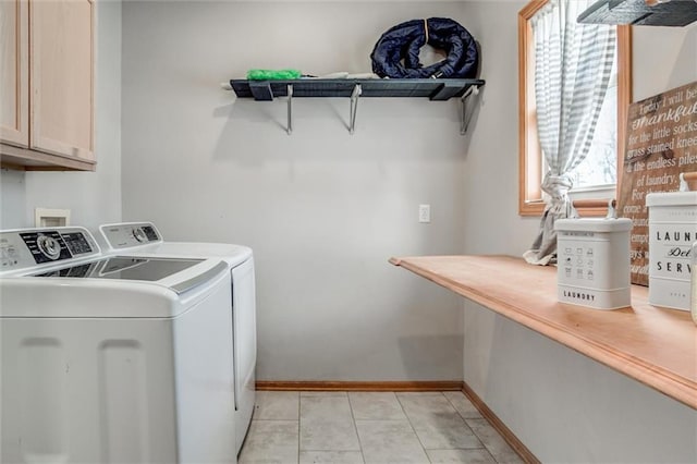 clothes washing area with separate washer and dryer, cabinets, and light tile patterned floors