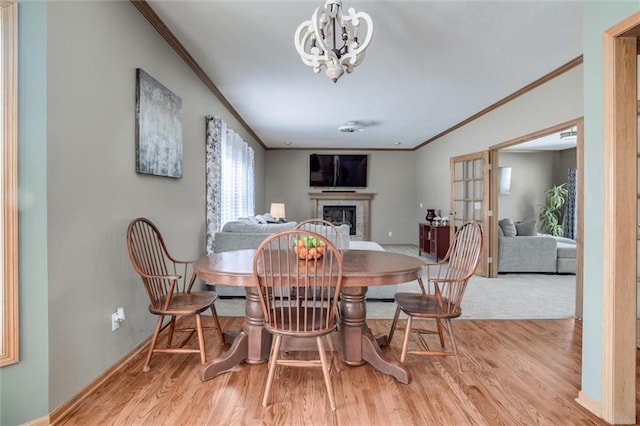 dining room featuring light hardwood / wood-style floors, crown molding, and an inviting chandelier