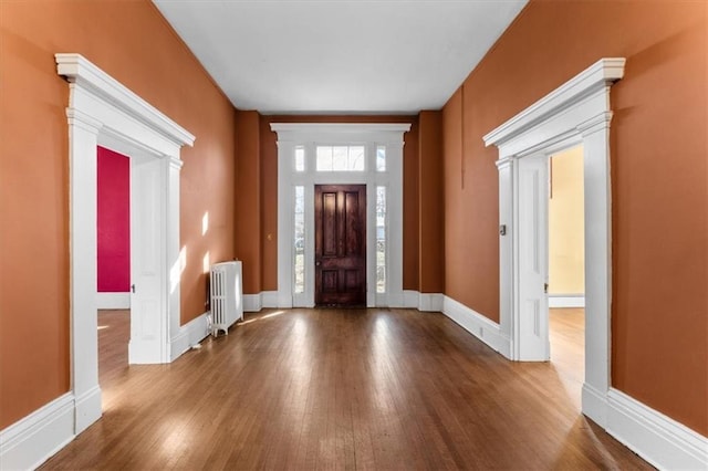 entryway featuring baseboards, radiator, and wood finished floors