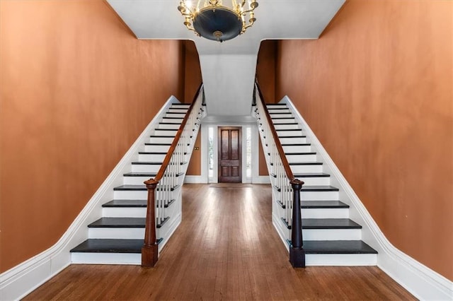 stairs with wood finished floors and baseboards