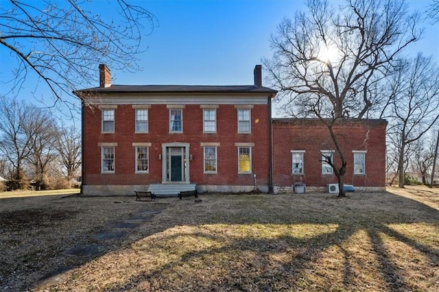 rear view of house with a yard and a chimney