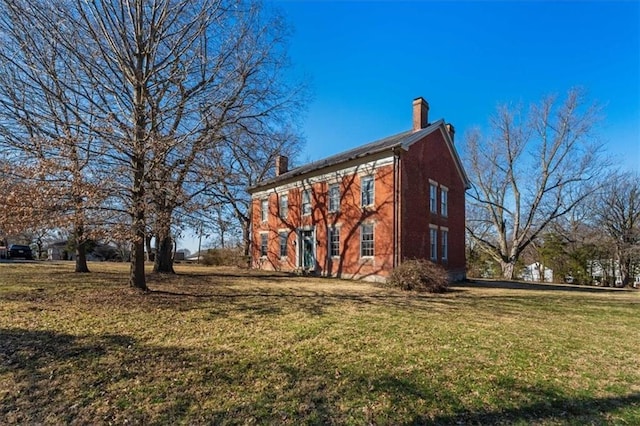 view of side of home featuring a lawn and a chimney