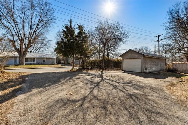 view of yard with a detached garage and an outdoor structure