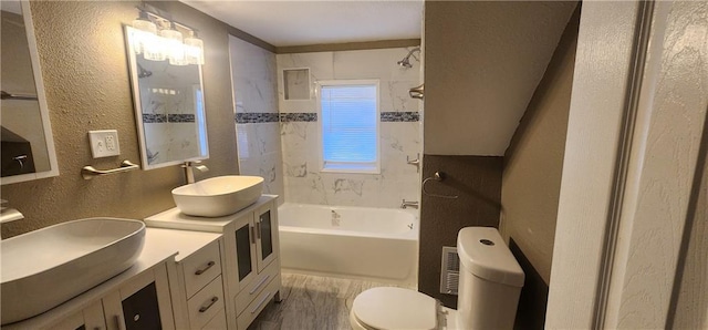 full bathroom with toilet, vanity, and tiled shower / bath