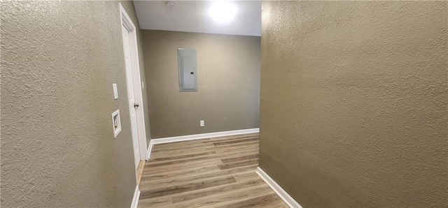 hall featuring electric panel and light hardwood / wood-style flooring