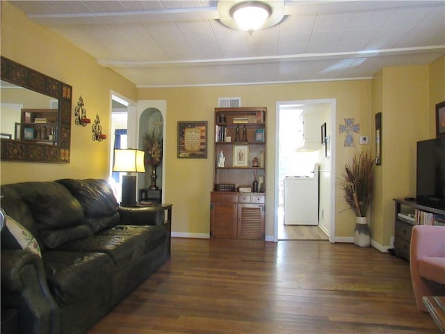 living room with dark wood-type flooring and washer / clothes dryer