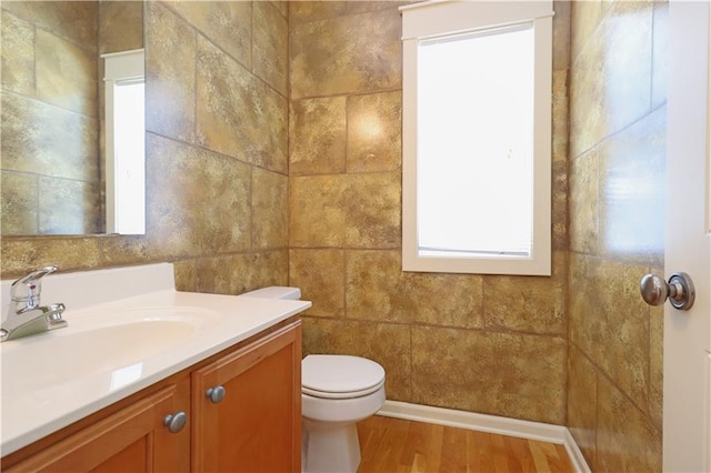 bathroom featuring toilet, wood-type flooring, and vanity