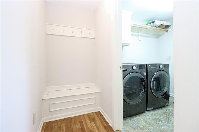 laundry room with washer and dryer and light wood-type flooring