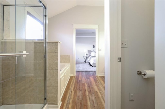 bathroom with plus walk in shower, hardwood / wood-style floors, and lofted ceiling