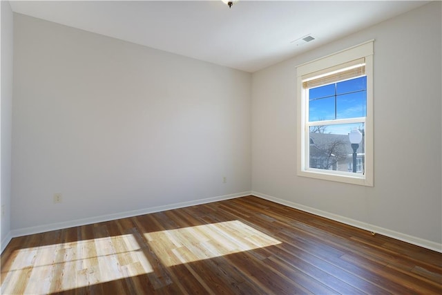 unfurnished room with dark hardwood / wood-style flooring