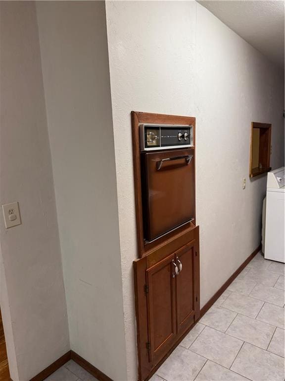 clothes washing area featuring light tile patterned floors and washer / clothes dryer