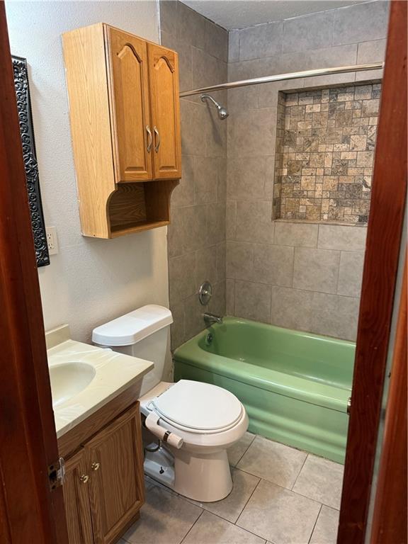 full bathroom with toilet, vanity, tiled shower / bath combo, and tile patterned floors