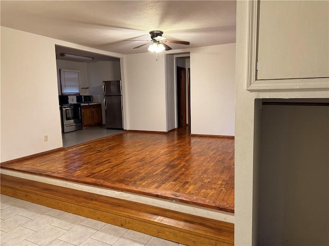 unfurnished living room featuring ceiling fan and light tile patterned flooring