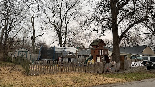 view of playground featuring a trampoline and a storage unit