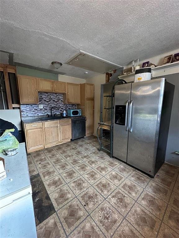 kitchen with backsplash, stainless steel appliances, sink, and a textured ceiling