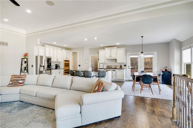 living room with crown molding, sink, and wood-type flooring